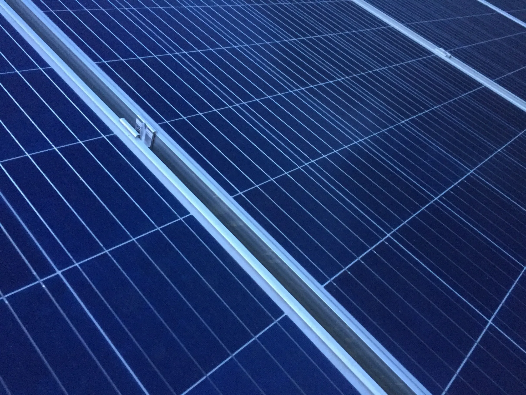 Close-up of a blue solar panel and its aluminum frame edge